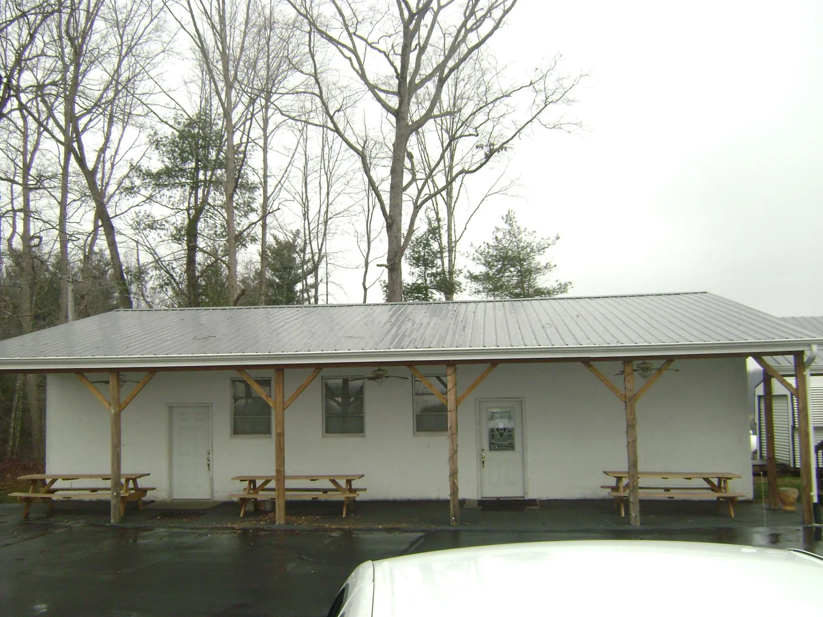 Gray metal roof over a block building with a timber post porch in Williamsburg